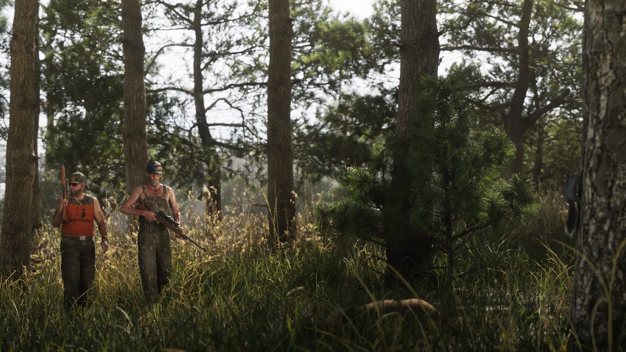 Two hunters walk through sunlit pine woods in Leonida in official GTA VI artwork, one in an orange tank top with a rifle over his shoulder and one in camouflage overalls carrying a scoped rifle, with tall grass in the foreground where a tan animal lies half-hidden